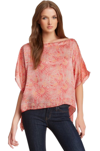 Woman wearing a pink floral blouse and blue jeans on a white background