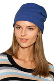 Woman wearing a blue 100% Cashmere beanie and striped sweater cashmere. subtle luxury cashmere hats