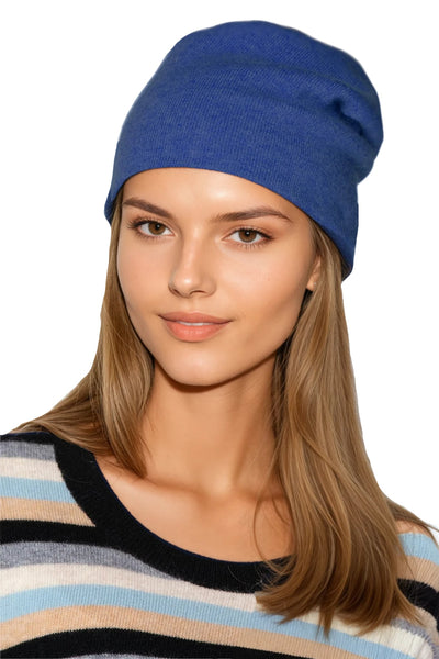 Woman wearing a blue 100% Cashmere beanie and striped sweater cashmere. subtle luxury cashmere hats