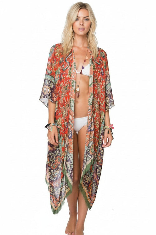 Model wearing a long Subtle Luxury modal kimono coverup in a vibrant orange and green masala print with raw edges. Masala Luxury Red Print Kimono Coverup