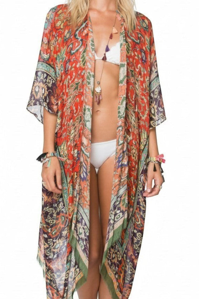 Model wearing a long Subtle Luxury modal kimono coverup in a vibrant orange and green masala print with raw edges. Masala Luxury Red Print Kimono Coverup