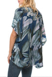 Woman wearing a blue floral kimono-style top on a white background