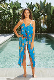 Subtle Luxury coastal summer dress in blue floral print with pom pom trim and braided straps by a swimming pool