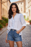 Subtle Luxury white cotton boyfriend shirt with electric blue embroidery worn by a woman with denim shorts